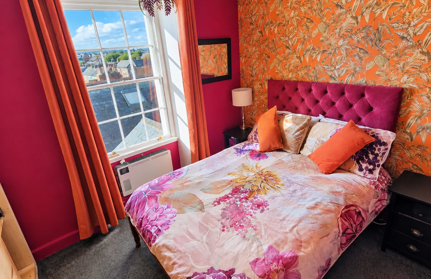 Double room with bold orange wallpaper at Philbeach Guest House